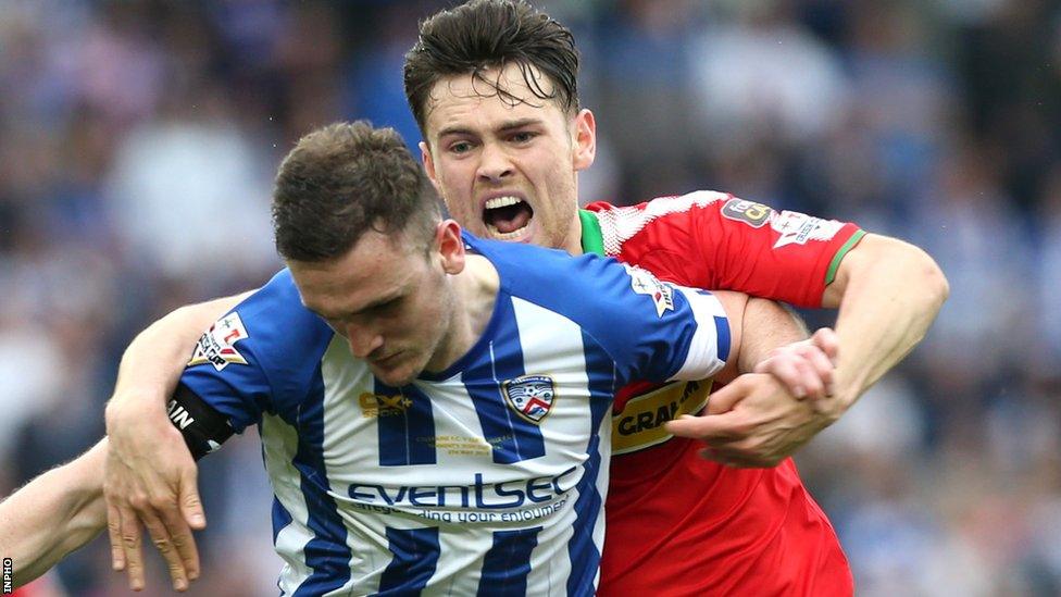 Coleraine skipper Stephen O'Donnell attempts to escape the clutches of Cliftonville opponent Conor McDonald