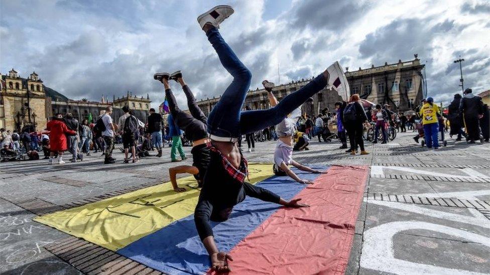 Youngsters dance during a protest against the government of Colombian President Ivan Duque during a national strike in Bogota on November 27, 2019