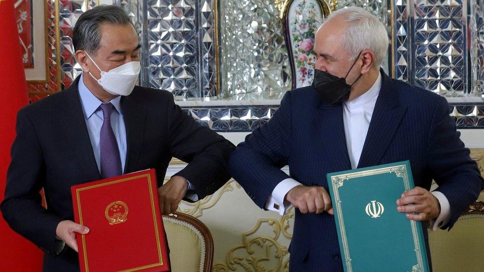 Chinese Foreign Minister Wang Yi and Iranian Foreign Minister Mohammad Javad Zarif bump elbows during the signing ceremony of a 25-year co-operation agreement in Tehran, Iran (27 March 2021)