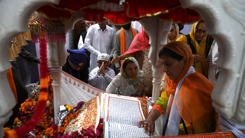 Sikh pilgrims take part in a religious ritual as they gather to celebrate the 550th birth anniversary of Guru Nanak Dev, at Nankana Sahib