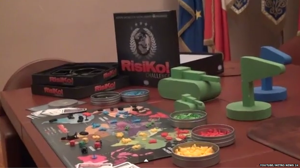 A view of the large playing pieces next to a standard side Risk board