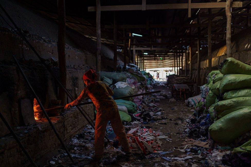 A woman feed the fire in the kiln