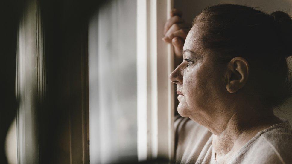 Woman standing at her window