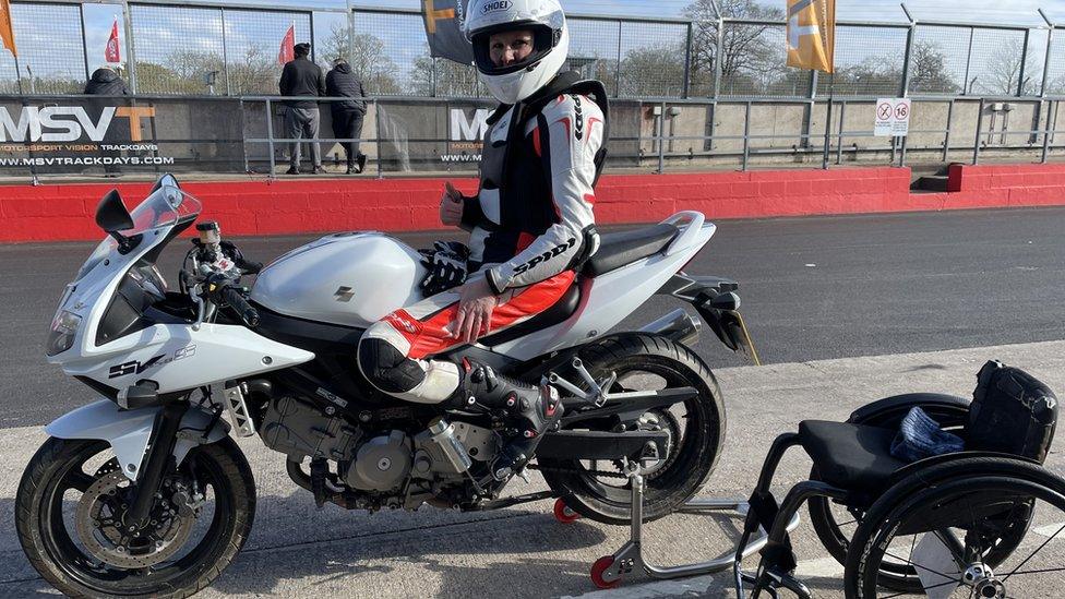 Claire Lomas on her bike with her wheelchair next to her