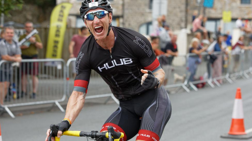 Gareth Thomas cheers to crowds at the Ironman Triathlon