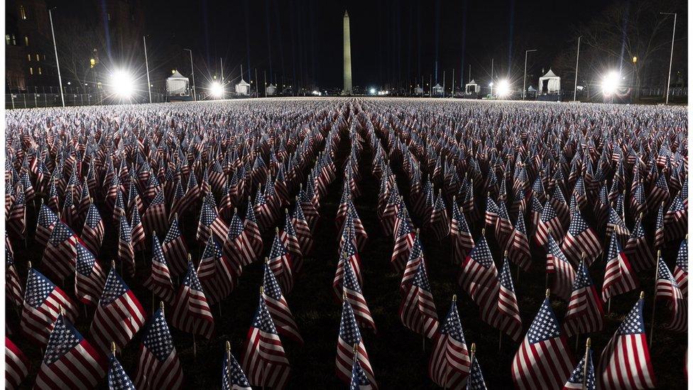 Wider shot of the flags placed in front of the Washington Monument.