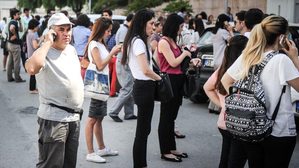 People stand in a street after being told to evacuate their buildings in Izmir after a 6.3 magnitude earthquake struck the Aegean coast of western Turkey, 12 June 2017