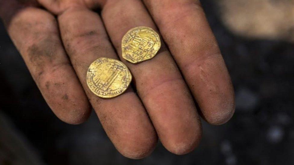 two-gold-coins-in-mans-hand