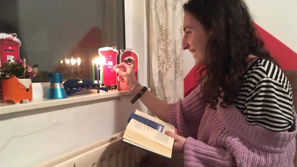 Raquel Schonker lighting a candle