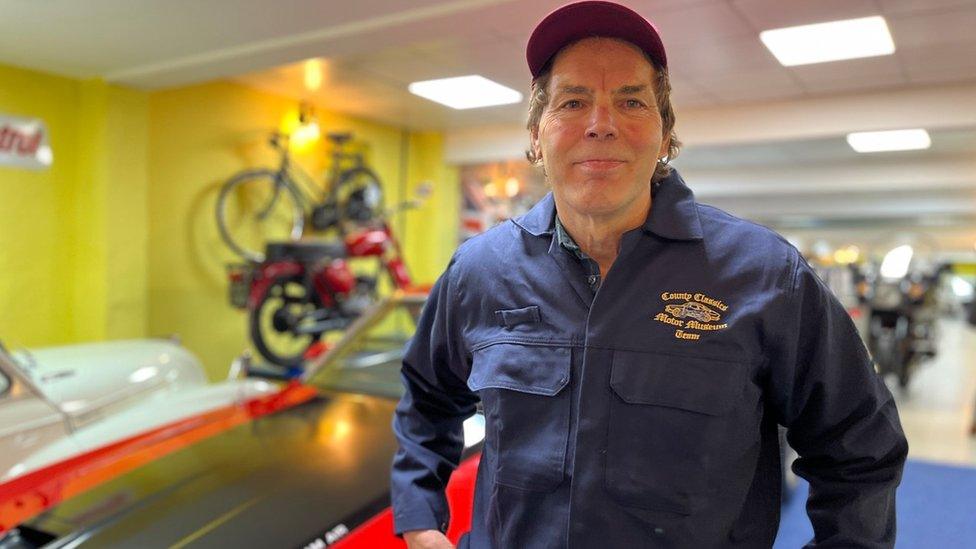 Patrick Hawkins standing inside his classic car museum