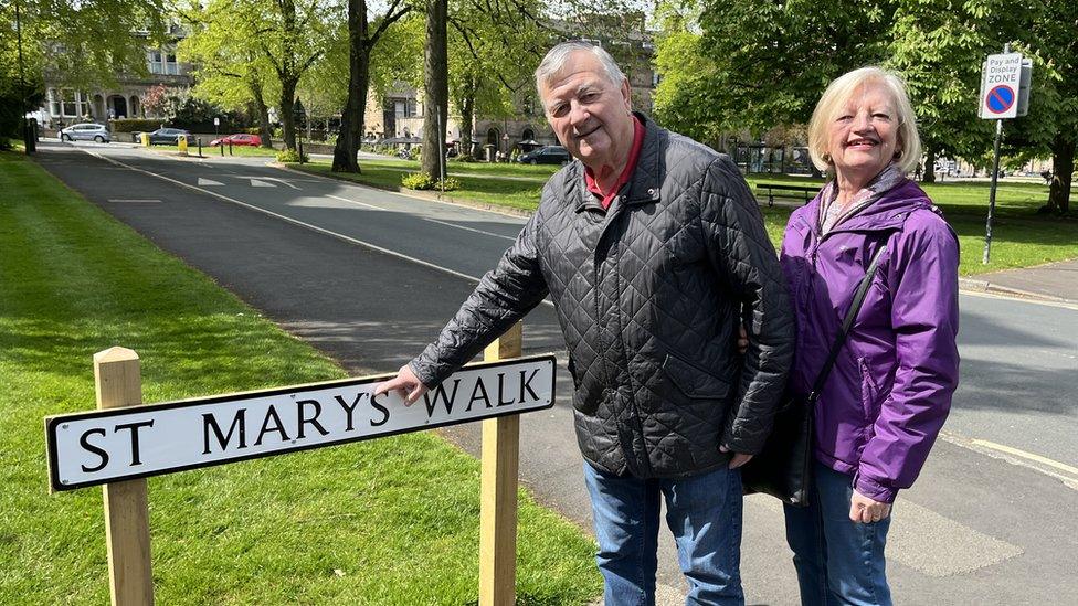 Couple pointing at street sign