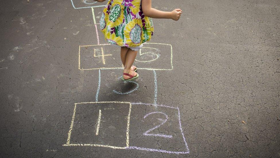 girl-playing-hopscotch-in-street