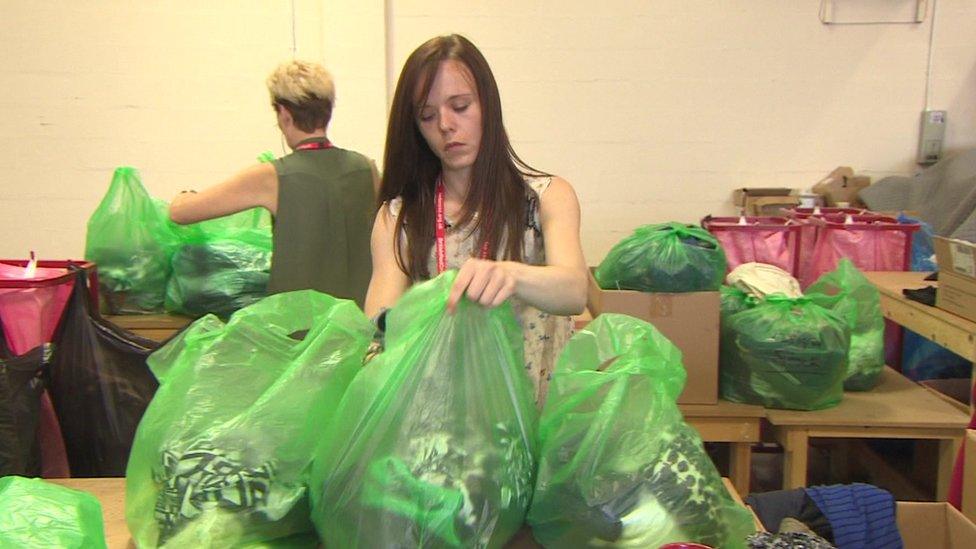 Woman sorts clothes donations