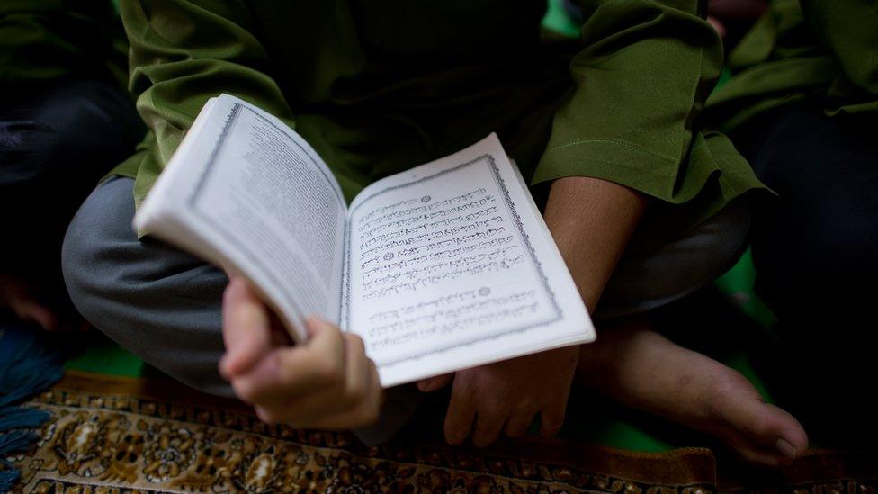 Boy reading a Koran