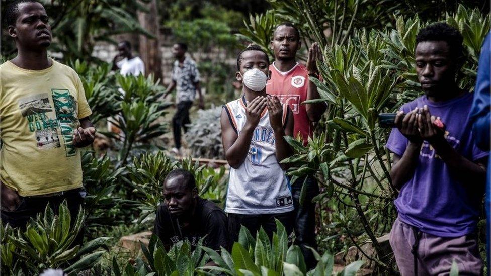 A friend of Yassin Hussein Moyo prays with a face mask on during Yassins burial at Kariokor Muslim Cemetery in Nairobi, Kenya on March 31, 2020