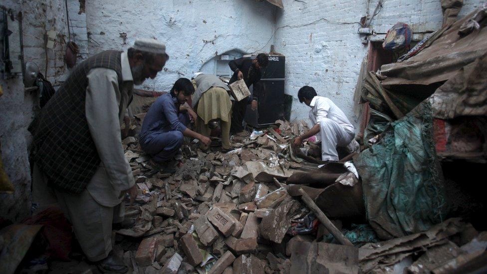 people search the rubble of a house in Peshawar