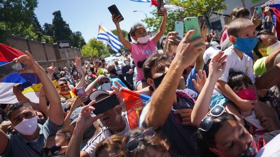 People hold their phones as they attend a funeral procession for Uruguayan former President Tabare Vazquez in Montevideo, Uruguay December 6, 2020.