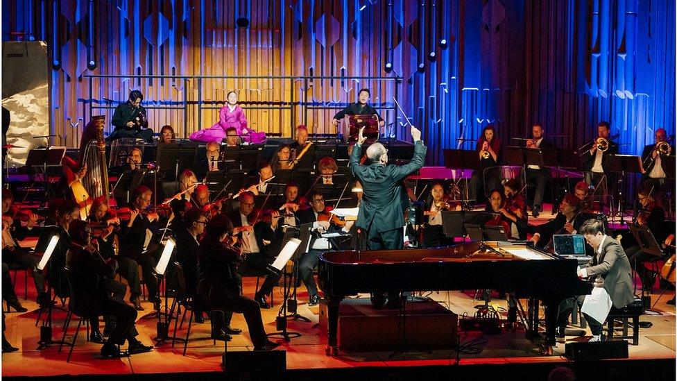 Jung and the orchestra performing with traditional Korean musicians