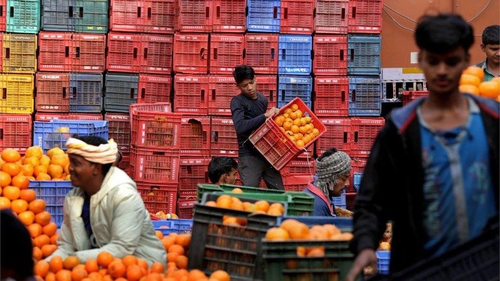 Indian laborers handle oranges at Mechua wholesale fruit market in Calcutta, eastern India, 21 January 2016.