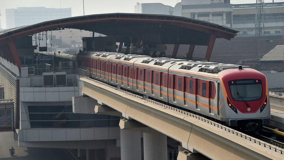 A train runs along the newly built Orange Line Metro in Lahore