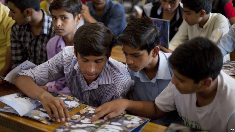 Pakistani boys study a comic book