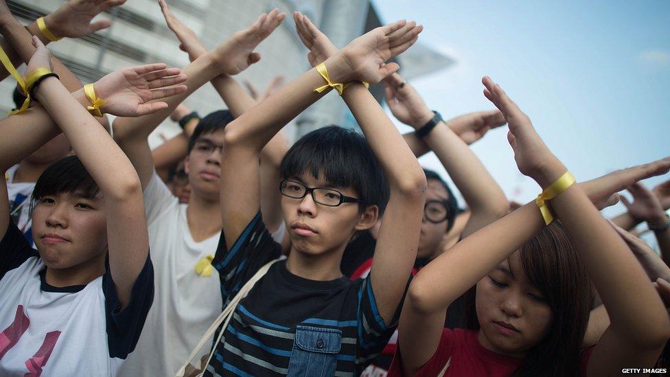 Student pro-democracy group Scholarism convenor Joshua Wong (C) makes a gesture at the Flag Raising Ceremony at Golden Bauhinia Square on 1 October 2014 in Hong Kong.