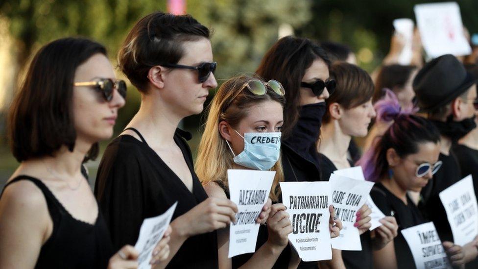 Romanian activists hold placards at a protest over Alexandra's kidnapping