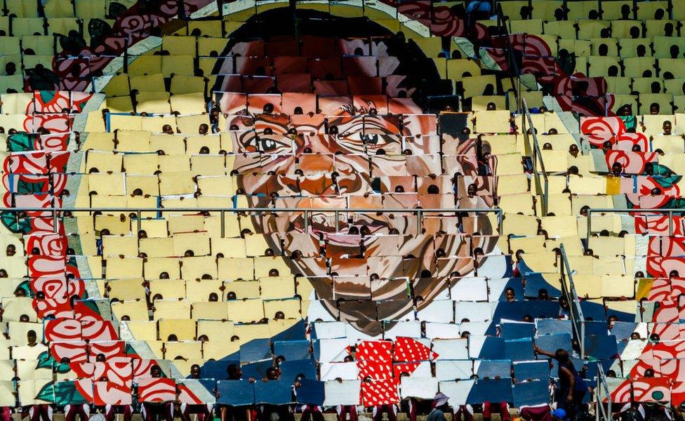 People display the portrait of Zimbabwe's President Emmerson Mnangagwa during Independence Day celebrations at the National Sports Stadium on April 18, 2018 in Harare. Zimbabwe on April 18 marked its first independence day without Robert Mugabe in power, with new leader Emmerson Mnangagwa vowing to hold 'credible' elections and turn around the southern African country's moribund economy.