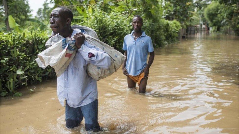 Men walking down flooded street