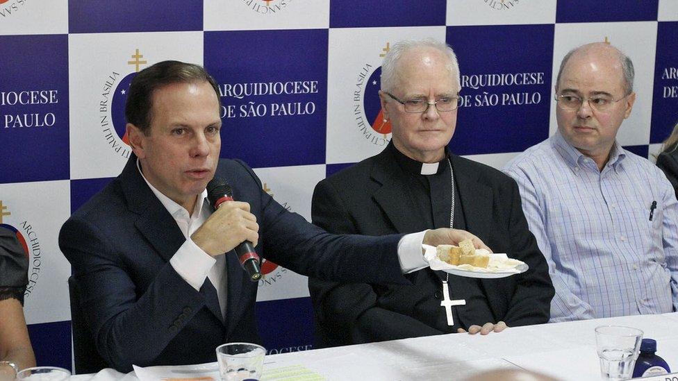 mayor Doria holds up bread he says has been made with farinata