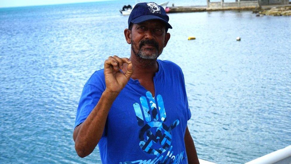 Devon Warner stands by the ocean in Barbuda