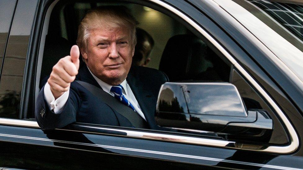 Donald Trump offers a thumbs-up from his car.