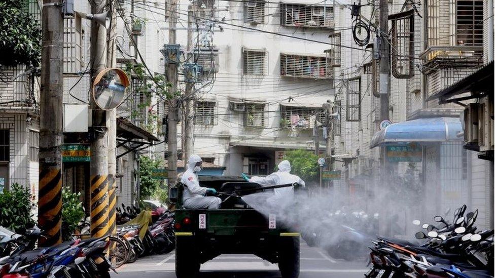 Soldiers wearing protective suits disinfect a street from a vehicle following the recent surge of coronavirus disease (COVID-19) infections, in Tucheng district of New Taipei City, Taiwan May 27, 2021.