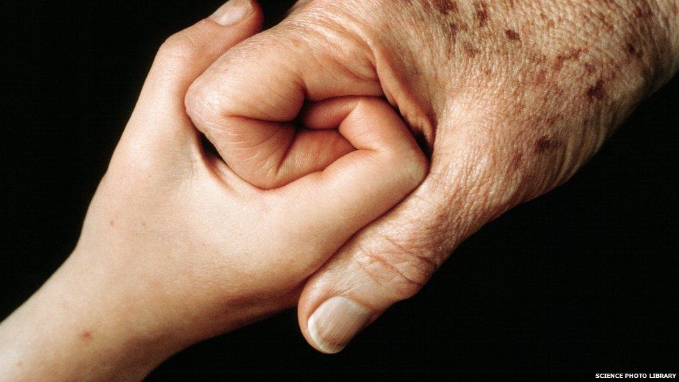 A young hand clasping and older hand