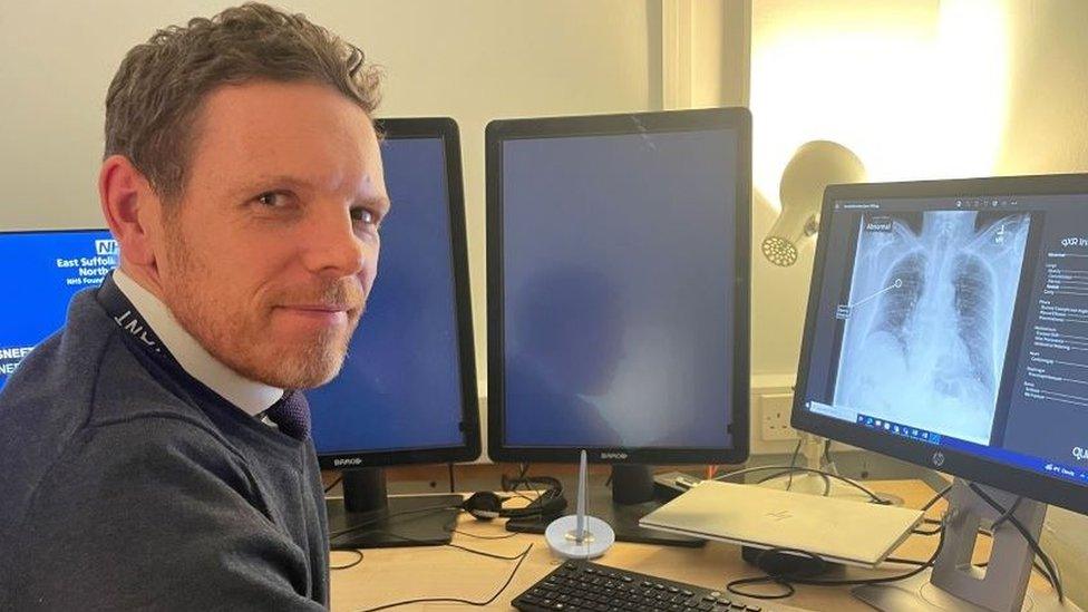 Consultant radiologist Dr James Hathorn sitting in front of a computer showing a chest x-ray