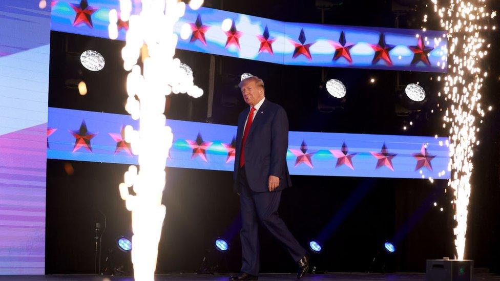 Donald Trump walks on stage to address the crowd at the Turning Point Action conference