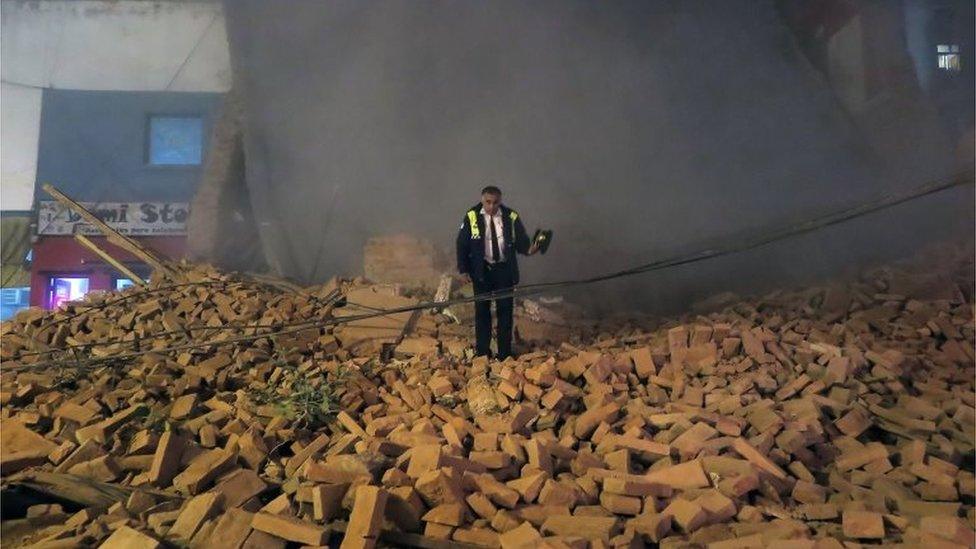 A policeman stands atop the rubble minutes after the collapse of the old Parravicini movie theatre building, in Tucuman, Argentina on May 23, 2018