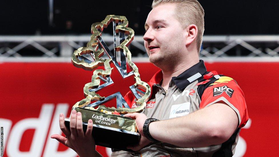 Dimitri van den Bergh celebrates with the UK Open trophy