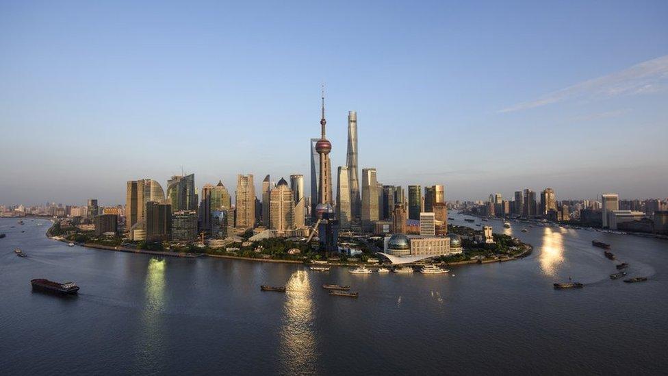 Ships pass by the skyline of the Lujiazui Financial District in Pudong in Shanghai