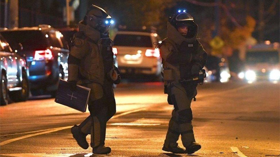 Police from the bomb squad unit walk near scene of the Melbourne siege