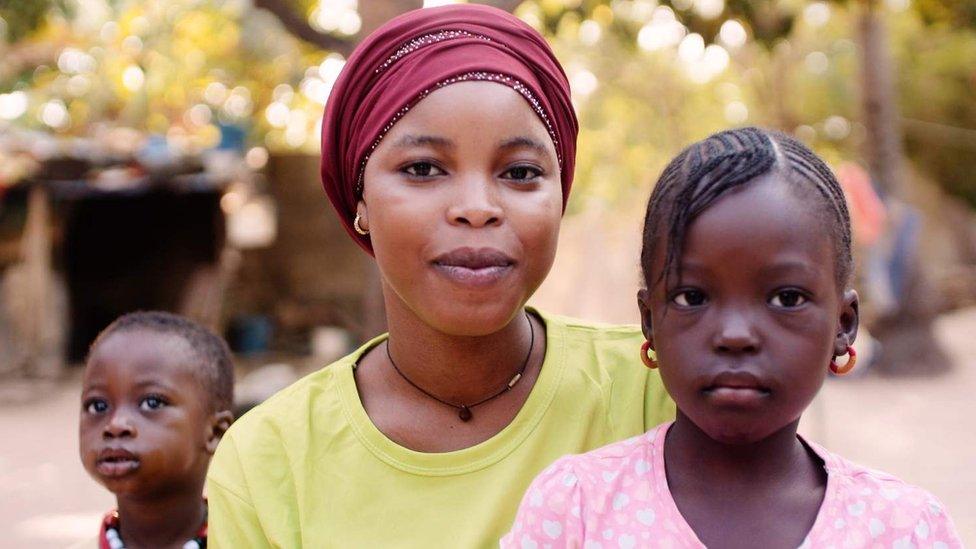 A woman with two children either side.