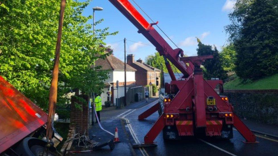 Lorry being lifted from wall