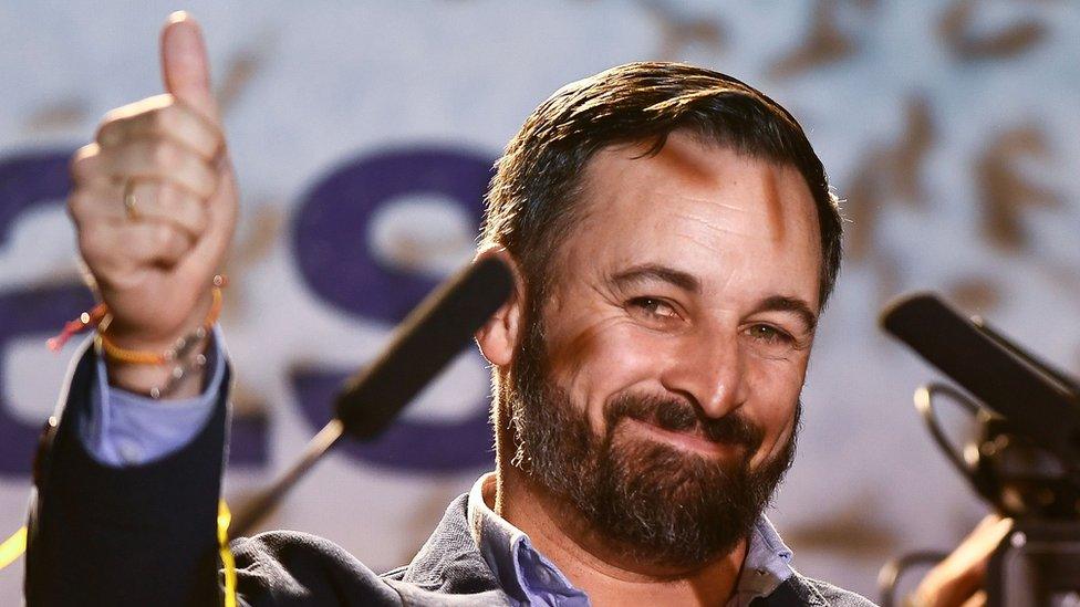 Santiago Abascal gives a thumbs-up to the camera while smiling on stage after the election results came in