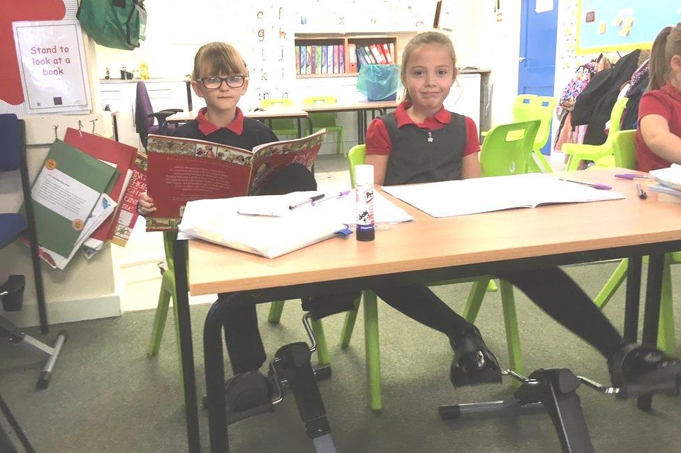 Pupils using pedal machines under their desks at school