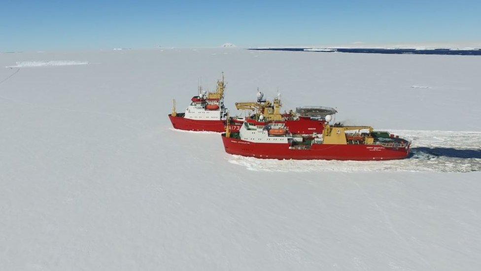 Two ships sailing through ice