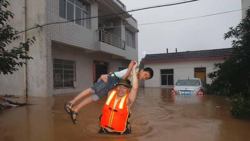 This picture taken on July 1, 2016 shows a boy being rescued from a flooded house in Xinzhou, in China's central Hubei province.