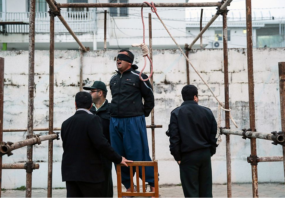 Balal, who killed Iranian youth Abdolah Hosseinzadeh in a street fight with a knife in 2007, reacts as he stands in the gallows during his execution ceremony in the northern city of Noor on April 15, 2014. Samereh Alinejad, the mother of Abdolah Hosseinzadeh spared the life of Balal, her son's convicted murderer, with an emotional slap in the face as he awaited execution prior to removing the noose around his neck.