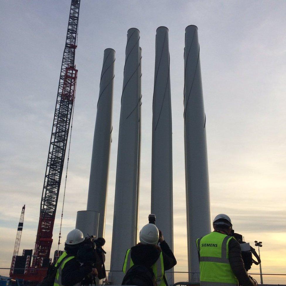 Three men photographing four towers