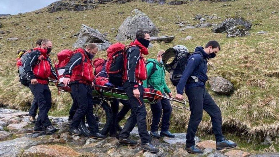 Tim Achub Mynydd Llanberis yn cludo un o'r ddwy fenyw