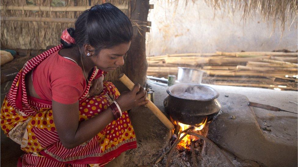 Woman cooking with firewood in India